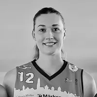 Une femme portant un maillot sportif avec le numéro 12 et un motif de silhouette de ville.