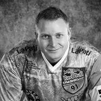 Un homme portant un maillot sportif à motifs avec divers logos de sponsors, notamment Red Bull et LaPati, et le texte 'owayo' sur la poitrine.