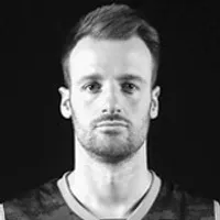 Un homme portant un haut sportif sombre à col en V, représentant des vêtements de sport personnalisés.