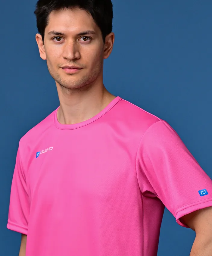 Un homme porte un maillot de sport rose vif devant un fond bleu.